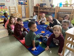 Photo of students in A Child\'s View sitting in a circle in their classroom.